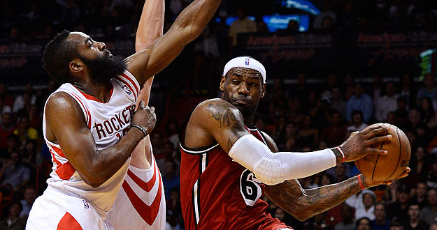 Miami Heat's James is defended by Houston Rockets' Aldrich and Harden during their NBA basketball game in Miami